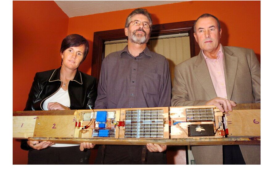 Catriona Ruane, Gerry Adams and Mitchel McLaughlin holding the bugging device found inside Connolly House in 2004.