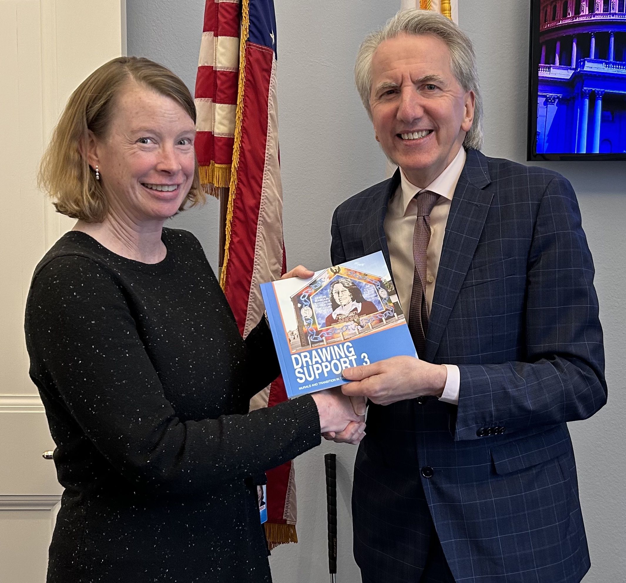 WRITING ON THE WALL: Presenting Lizzy O'Hara, Chief of Staff to Congressman Richie Neal with a book on Belfast murals. Ms O'Hara has been working with the Congressman on Irish peace process issues since the nineties.