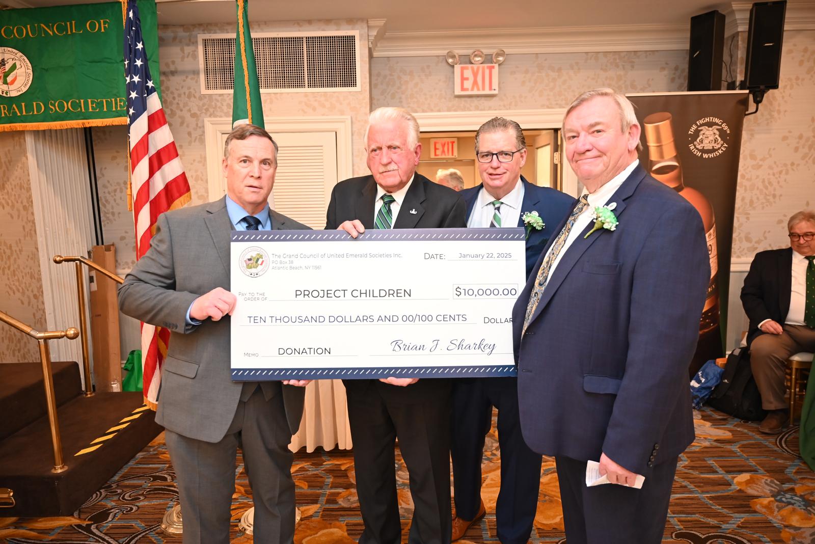 FUNDS BOOST: The Emeralds' Cigar Night Committee presents Denis Malachy with a check for $10,000 for the work of Project Children
