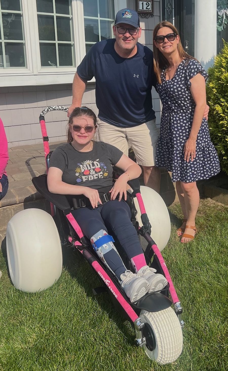 NEW WHEELS: Lauren Richardson celebrates receiving a new beach-access wheelchair with Pat and Marianne Bergin